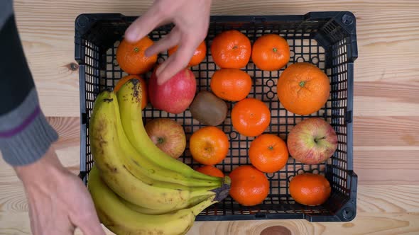 A Man's Hands Lay Ripe Tangerines an Exotic Fruit in a Delivery Box During a Pandemic