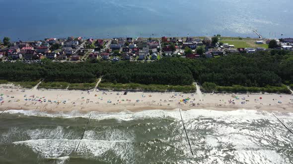 Beach Chalupy resort in Poland. Aerial video. Baltic Sea. People on towels. Waves