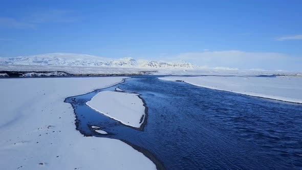 Aerial View of a Blue River in a Snowy Landscape