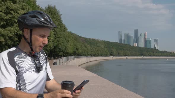 Man Sportswear Riding a Bicycle Helmet Is Resting on a Beautiful City Promenade