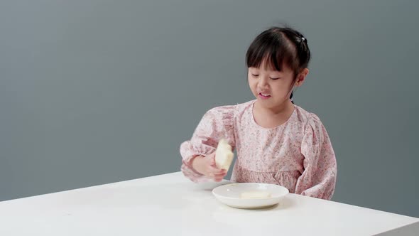 Happy Asian girl smile and enjoy eating crispy butter toast at home.