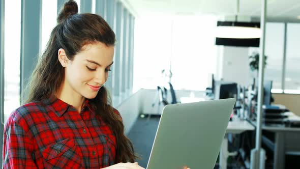 Smiling female executive using laptop