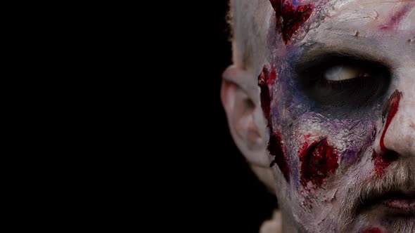 Zombie Man Face Makeup with Wounds Scars and White Contact Lenses Looking at Camera Trying to Scare