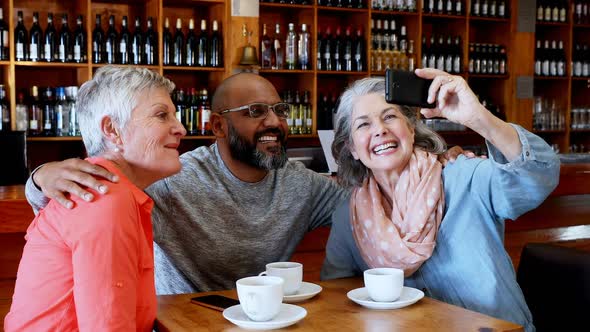 Friends taking selfie with mobile phone in bar 4k