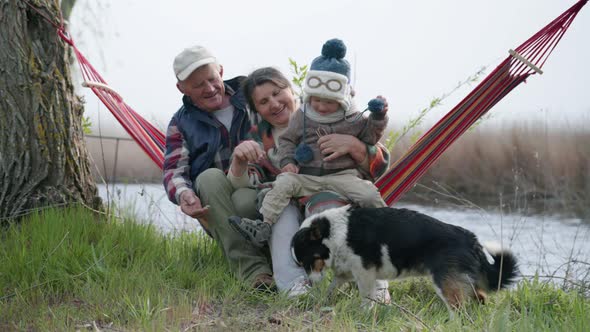 Parenthood, Cheerful Married Couple, Happy Grandparents Have Fun with Their Grandson Playing with a