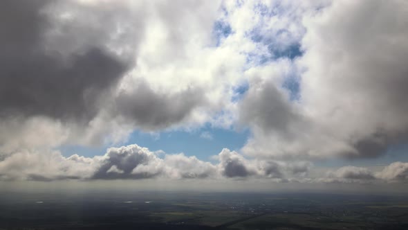 Aerial View at High Altitude of Earth Covered with Puffy Cumulus Clouds Forming Before Rainstorm