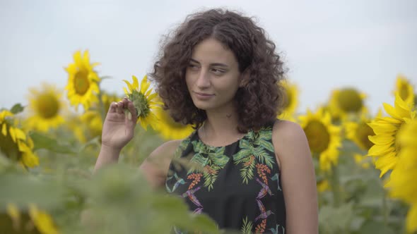 Portrait of Beautiful Curly Girl Looking at the Camera Smiling and Covering Her Eye with Little