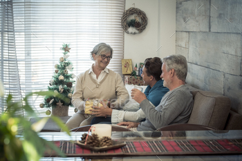 Family at home enjoying and celebrating christmas time night together with presents and gits