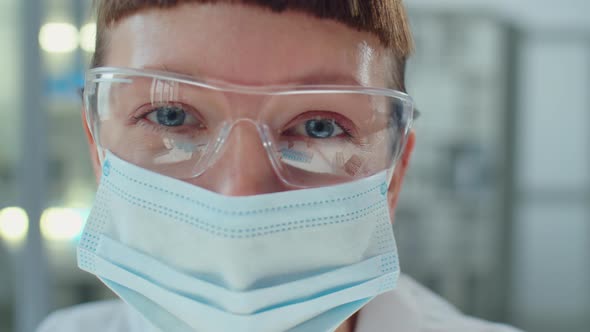 Portrait of Masked Female Scientist in Protective Glasses