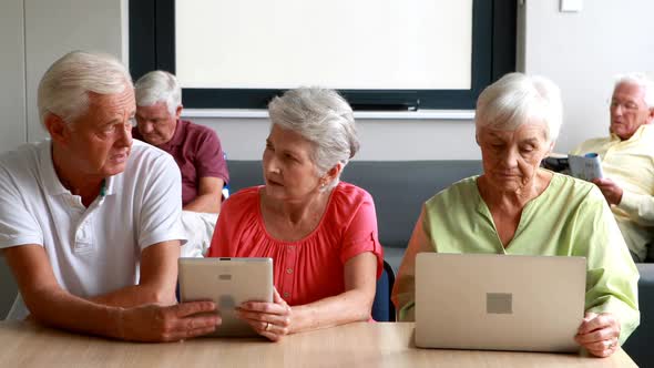 Senior citizens using digital tablet and laptop