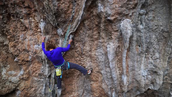 Slow Motion Back View Female Rock Climber Climbs on Overhanging Limestone Cliff By Tough Route