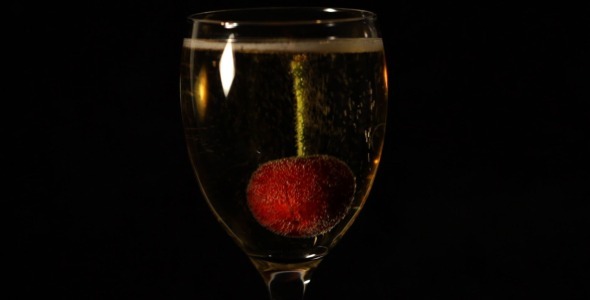 Cherry Dropped Into Sparkling Wine Glass
