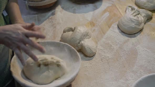 The Hands of the Bakers Kneading Forms of Dough for Bread Baking on Table