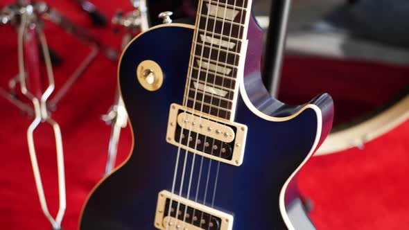 A vintage blue electric guitar on a concert stage in a rock and roll garage band setting.