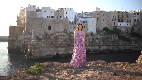 Slow motion of pretty woman standing in front of the sea