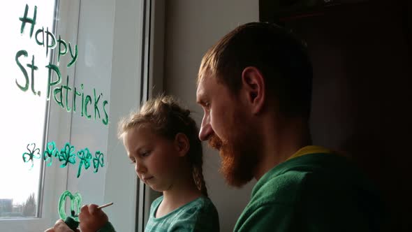 Drawing St. Patrick's Day Father daughter painting green three-leaved shamrocks indoor Clover leaves