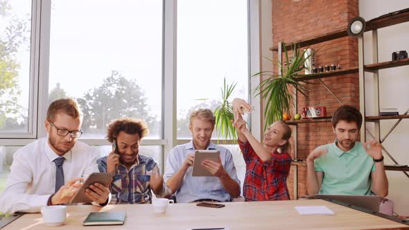 Blonde Caucasian Female in Plaid Shirt Making Selfie on Mobile Phone While Her Interracial Friends