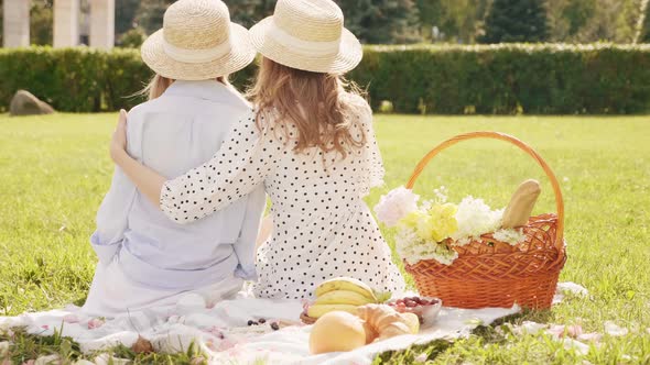 Two young beautiful hipster woman in trendy summer sundress and hats posing outdoors