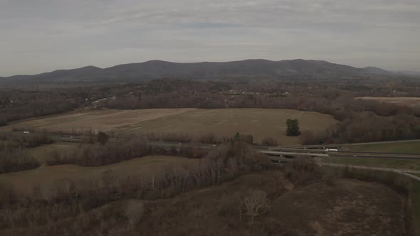 A beautiful landscape with mountains in the background of a highway with light traffic in a rural ar