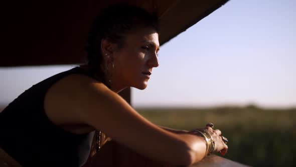 Young Hippie Woman Looking Out Window on Summer Sunny Day