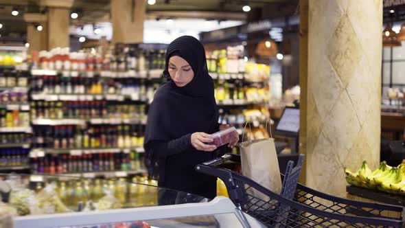 Muslim Woman Shopping for Groceries Taking Some Berries From the Fruit Aisle