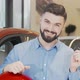 Happy Attractive Man Showing Car Keys to the Camera at Dealership Salon - VideoHive Item for Sale