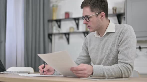 Young Man Working on Documents Paperwork