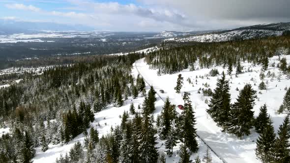 Aerial View of Car Moving By Snowed Road in Mountains