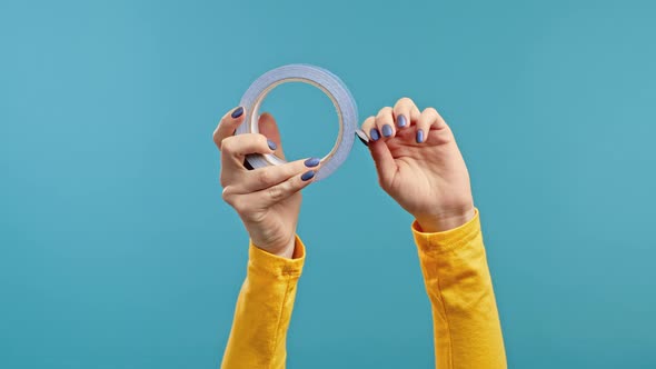 Female Hands with Adhesive Tape on a Blue Background