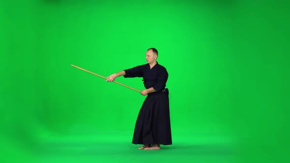 Masculine Kendo Warrior Practicing Martial Art with the Bamboo Bokken on Green Screen, Slow Motion