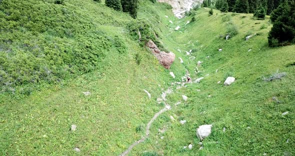 A Guy with a Backpack is Walking in the Mountains