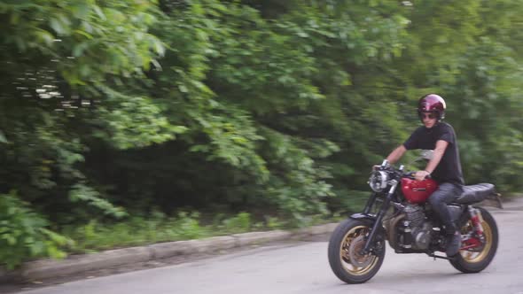 A Biker Rides on His Cafe Racer Motorcycle