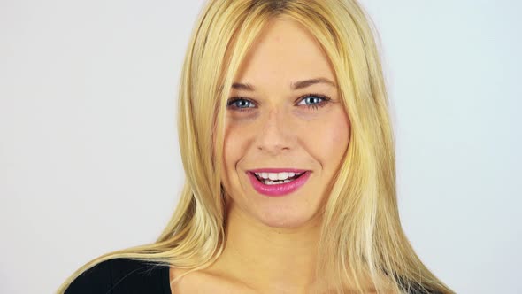 A Young Attractive Woman Talks To the Camera with a Smile - Face Closeup - White Screen Studio