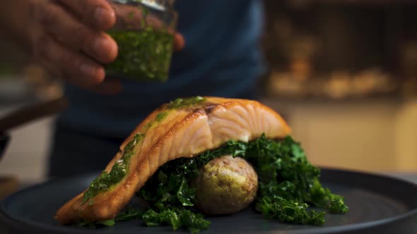 Close up shot of chef marinates grilled salmon with healthy spinach in restaurant.Serving high quali