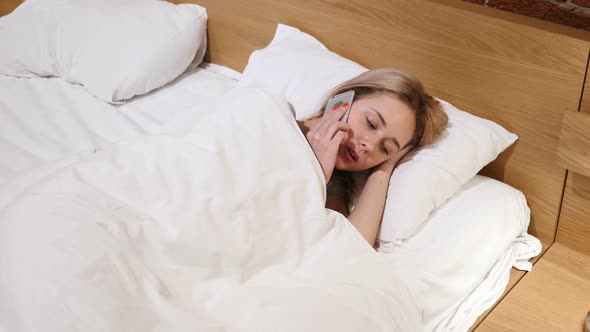 Woman Lying  in Bed  Talking on Mobile Phone