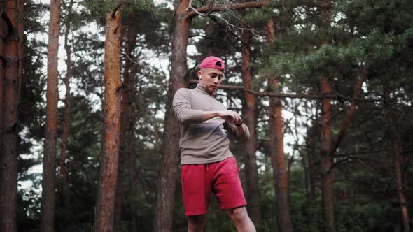 Young Asian Man Warming Up at Forest Road Before Jogging