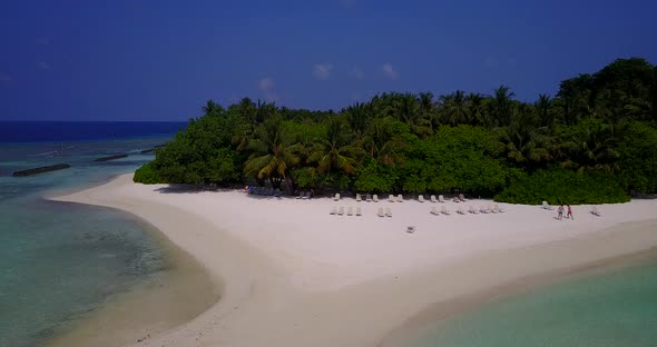 Wide angle birds eye travel shot of a sandy white paradise beach and aqua turquoise water background