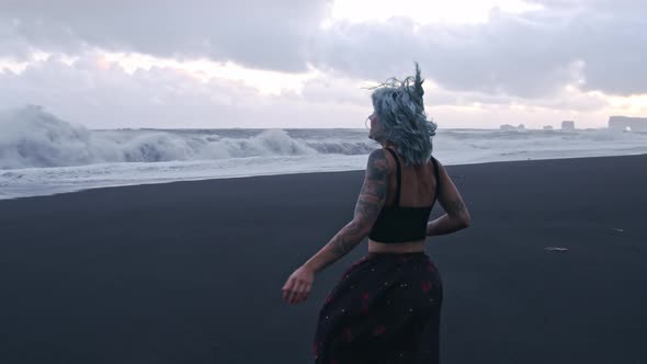 Blue Haired Girl Running On Black Sand Beach