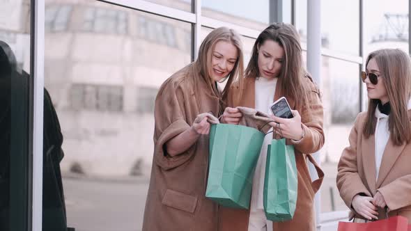 Pretty Girls Are Checking Shopping Bags with Clothes