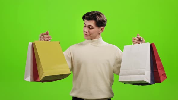 A Man is Holding Shopping Bags in Both Hands
