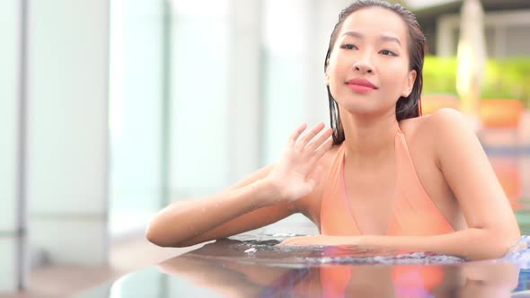 Young asian woman enjoy around outdoor swimming pool for leisure