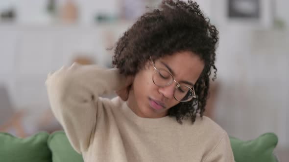 Portrait of Young African Woman with Neck Pain at Home 