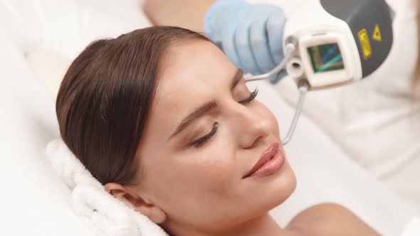 Close-up of Woman Face at Spa Having Tratment with Neodymium Apparat