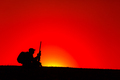 Sniper, hunter siting on hill with rifle on sunset - PhotoDune Item for Sale