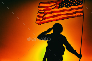  service rifle, holding USA national flag, saluting on background of sunset or dawn sky. Military respect and honor, patriotism and heroes remembrance
