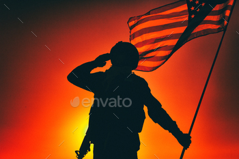 olding USA national flag, saluting on background of sunset or dawn sky. Military respect and honor, patriotism veterans and heroes remembrance
