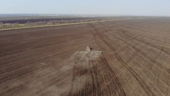 Aerial Footage Modern Red Tractor on the Agricultural Field on Sunny Day