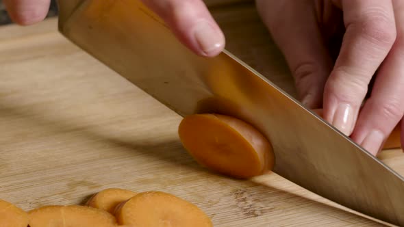 slicing raw carrot on cutting board