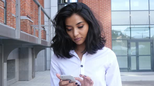 Girl Walking and Using Smartphone for Online Browsing