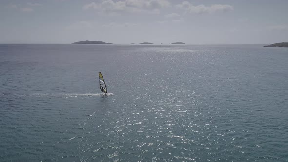 Aerial view of man doing windsurfing at a beach in Greece.